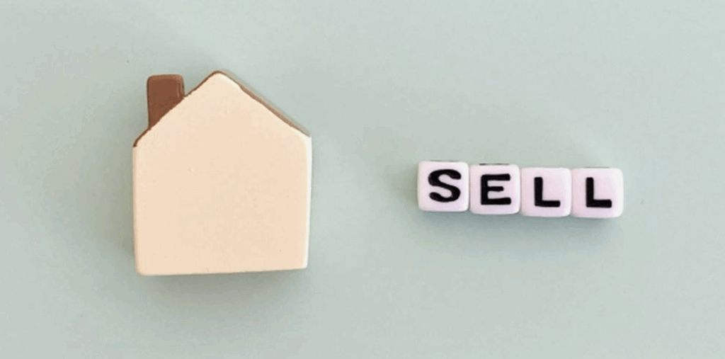 家の形のオブジェと「SELL」の文字ブロック。