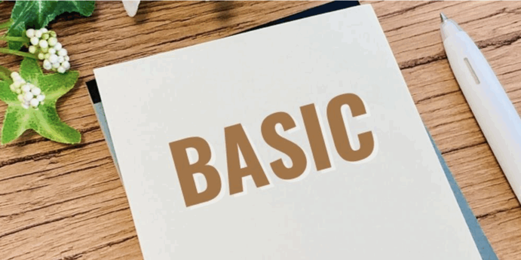 「BASIC」と書かれたノートとペン、テーブル上のグリーン装飾