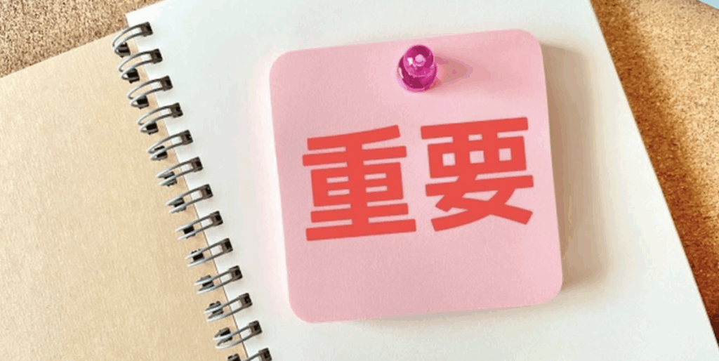 『重要』と書かれたピンクの付箋がノートにピン留めされているイメージ